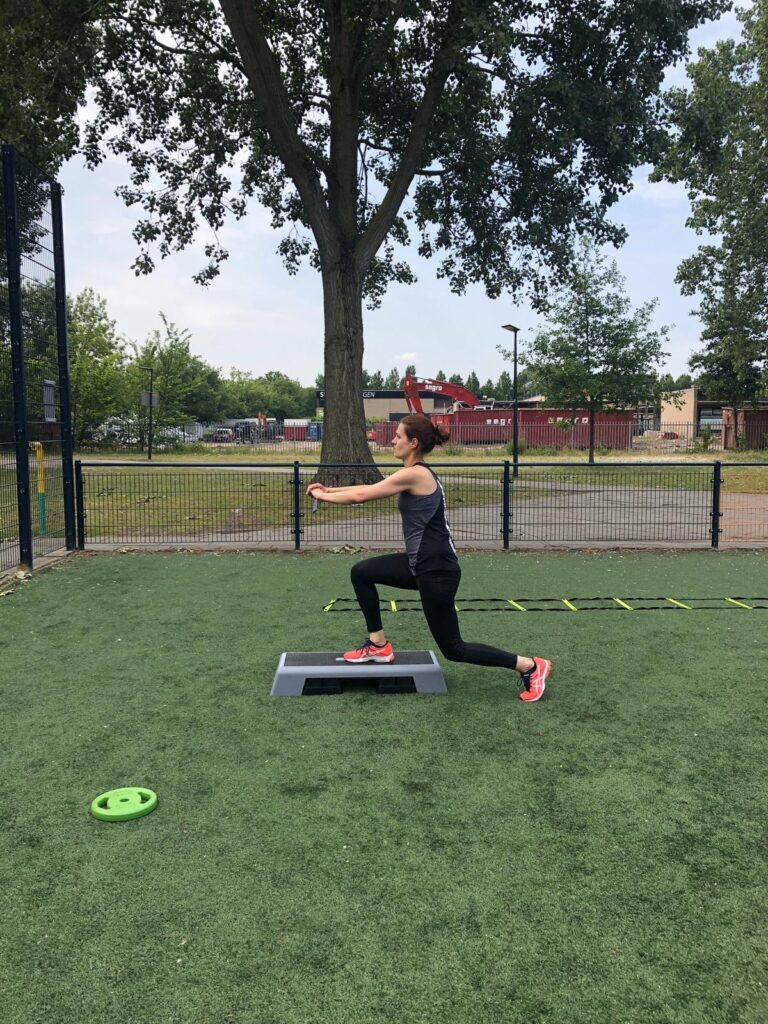 Vrouw in sportkleding traint buiten op een veldje